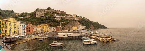 Obraz na płótnie Sorrento, Italy - July 24, 2024: Wide angle view of Sorrento town showing boats, deck, coast, buildings and tourists w salonie