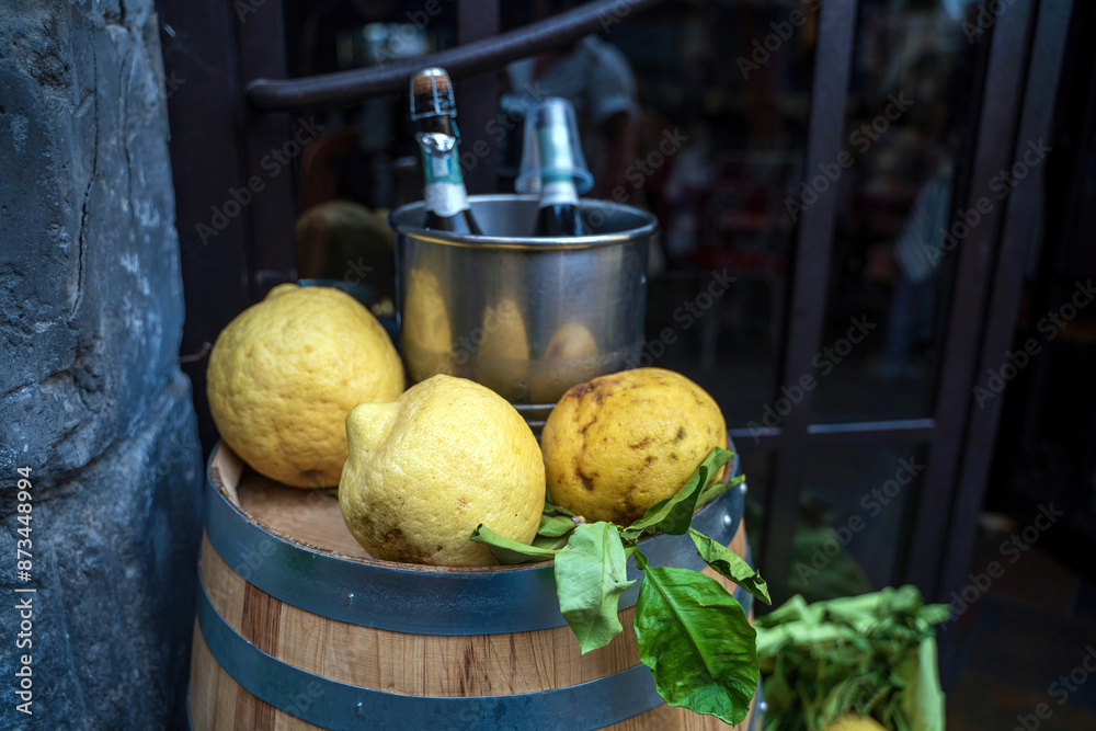 Huge lemons kept on a shelf barrel against bottle of wine in a famous city of Sorrento, Italy