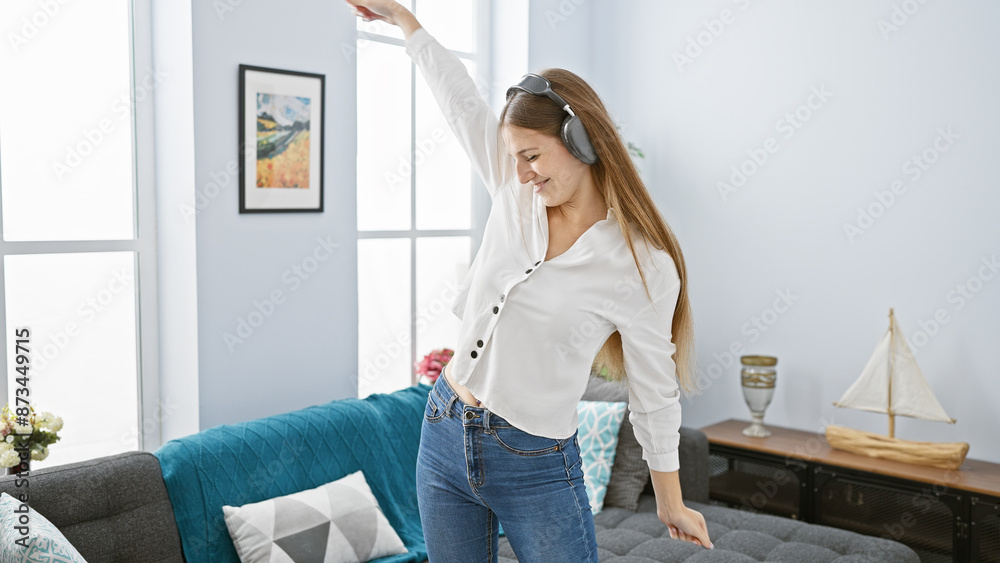 A happy young woman enjoying music with headphones in a cozy, modern living room setting. A happy young woman enjoying music with headphones in a cozy, modern living room setting.