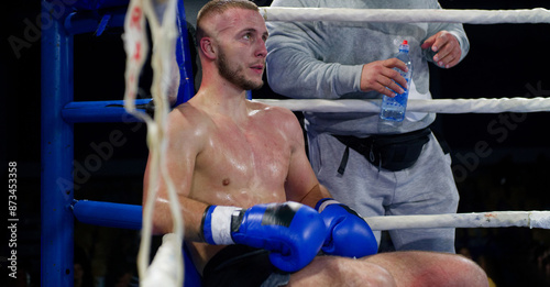 Obraz na plátně Cornered boxer receives strategic advice from trainer during intense bout