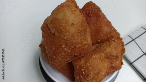 Bolang baling, Odading, fried bread in cubes or blocks, with a light brown crunchy outer skin and sprinkled with sesame seeds, the inside is empty and fluffy, so it looks like a small pillow. photo