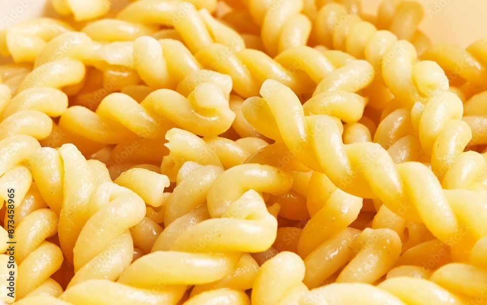 Close-up of cooked fusilli pasta with a glossy surface, ideal for culinary themes and recipe visuals. Close-up of cooked fusilli pasta with a glossy surface, ideal for culinary themes and recipe visuals.