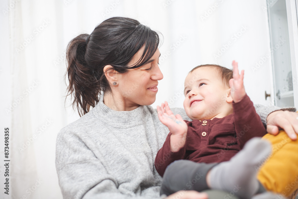 A look of complicity between mother and toddler as they relax in a living room armchair Motherhood concept. A look of complicity between mother and toddler as they relax in a living room armchair Motherhood concept.