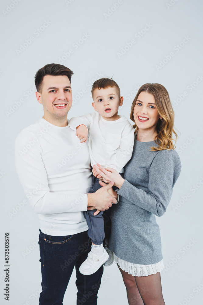 A happy married couple with a little son. Mom, dad and smiling son. Stylish family. A happy married couple with a little son. Mom, dad and smiling son. Stylish family.