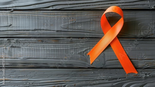 Grey table with orange ribbon top view for multiple sclerosis awareness