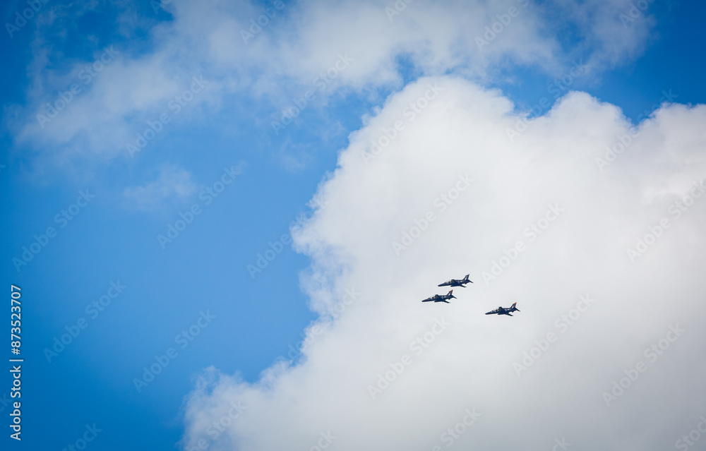 Three Hawk fighter jets flying in formation back to their air base after taking part in the kings birthday fly past, Image shows the trainer aircraft with a blue sky and slight white cloud background Three Hawk fighter jets flying in formation back to their air base after taking part in the kings birthday fly past, Image shows the trainer aircraft with a blue sky and slight white cloud background