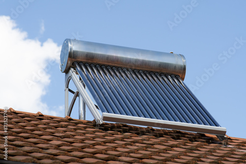 solar water heater on a roof top, solar water heating panel, blue sky in the background