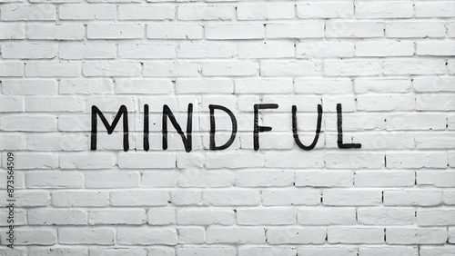 Painted black mindful inscription on white brick wall background