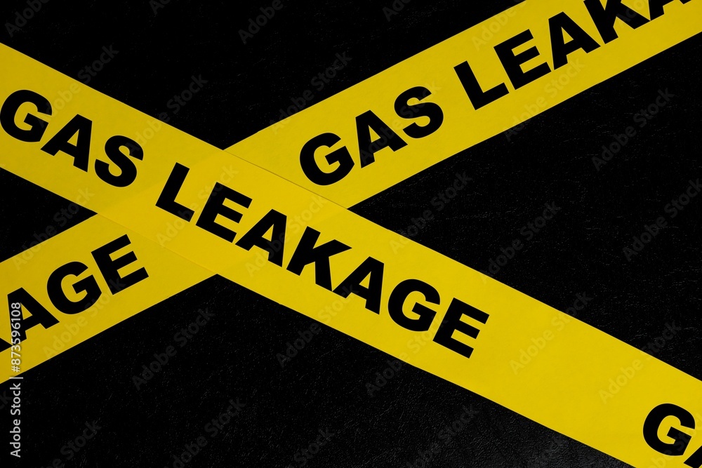 Gas leak or leakage caution danger and warning concept. Yellow barricade tape with word in dark black background.