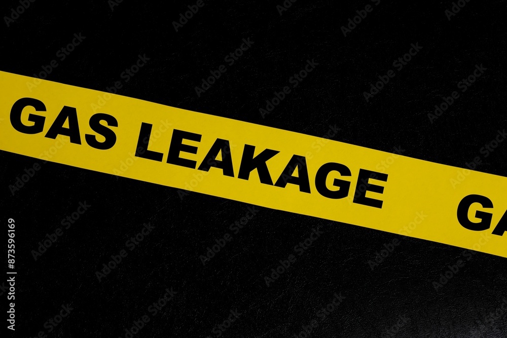 Gas leak or leakage caution danger and warning concept. Yellow barricade tape with word in dark black background.