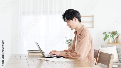自宅でノートパソコンを使う男性