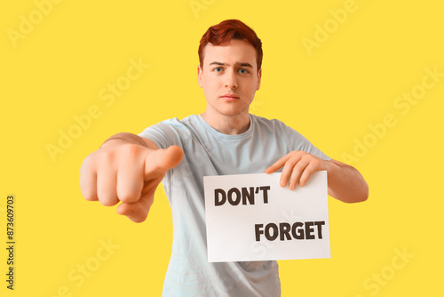 Young man holding paper wit...