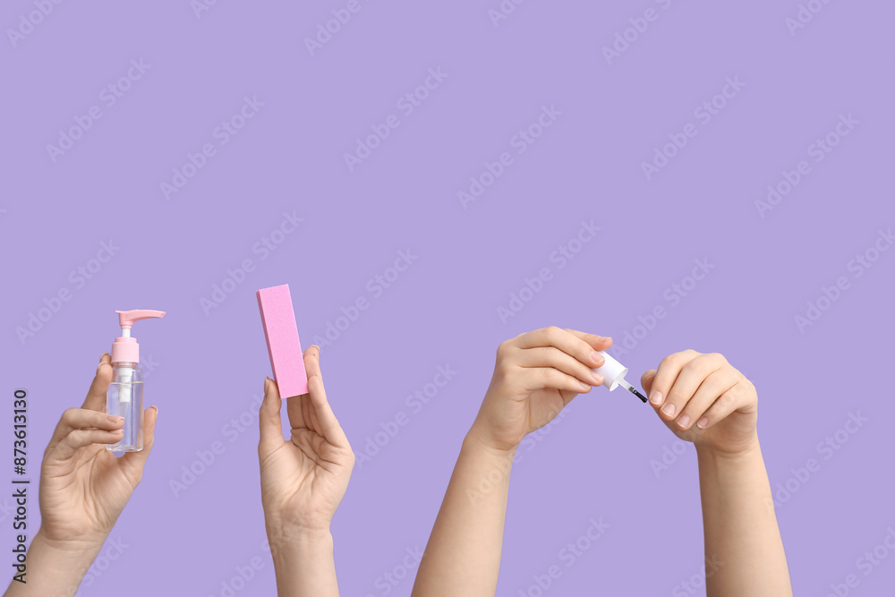 Female hands with bottle of cuticle oil, brush and buffer on lilac background Female hands with bottle of cuticle oil, brush and buffer on lilac background