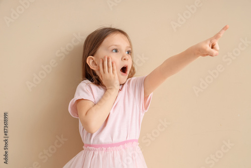 Shocked little girl pointin...