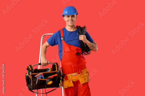 Smiling electrician in over...