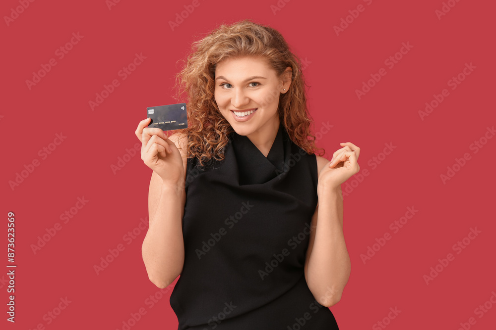 Happy young woman with credit card on red background Happy young woman with credit card on red background