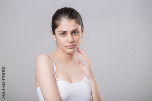 Perfect Female With Grave Expression Keeping One Hand On Her Chin While Looking At The Camera