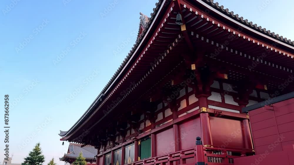 Traditional Japanese temple with vibrant red details under a clear blue sky Traditional Japanese temple with vibrant red details under a clear blue sky