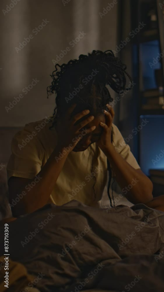 Vertical full shot of young Black lady with ptsd staying awake at night in bedroom and having panic attack, experiencing troubles falling asleep due to strong traumatic memories Vertical full shot of young Black lady with ptsd staying awake at night in bedroom and having panic attack, experiencing troubles falling asleep due to strong traumatic memories