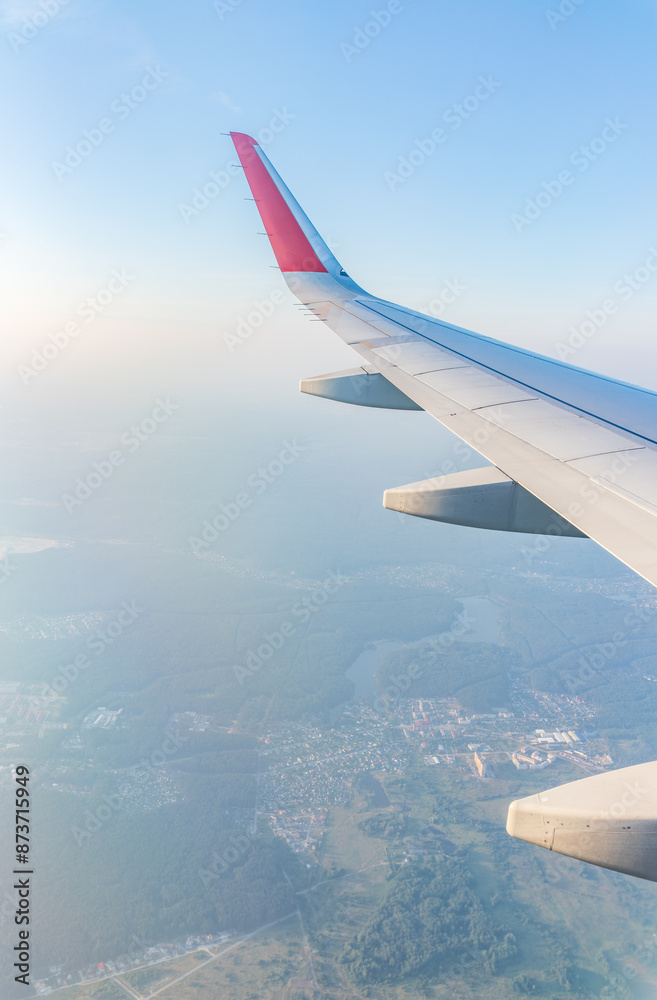 Fototapeta premium View from the airplane window at a beautiful cloudy sky and the airplane wing
