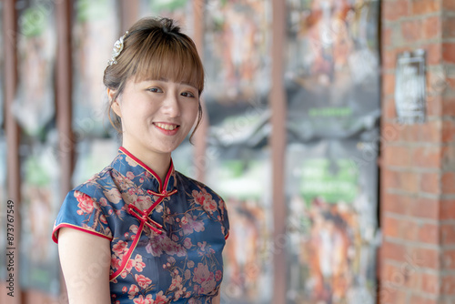 Young Taiwanese woman in her 20s wearing a blue cheongsam, strolling through a cultural district in Wanhua, Taipei, Taiwan photo