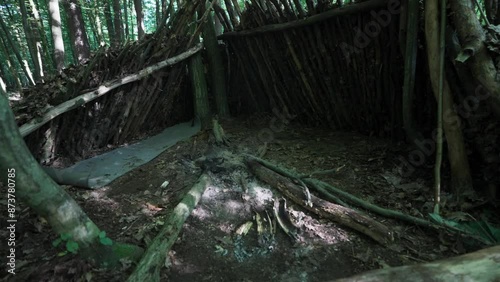 Survival shelter built for sleeping with a campfire in the forest