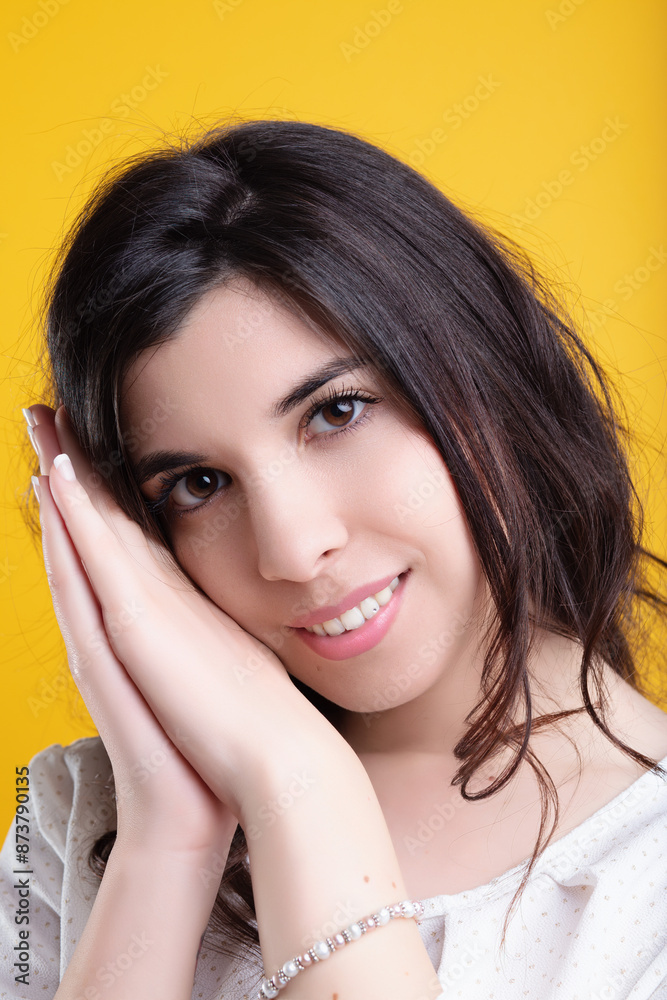 Beautiful young woman with long brown hair resting her cheeks on Beautiful young woman with long brown hair resting her cheeks on