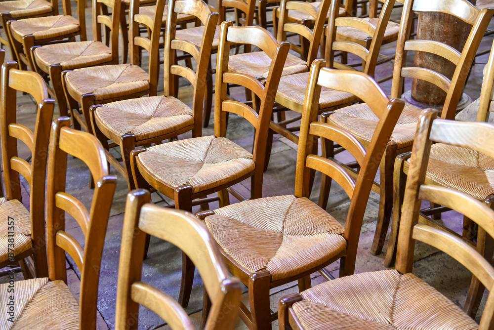rows of old wooden chairs in an empty room