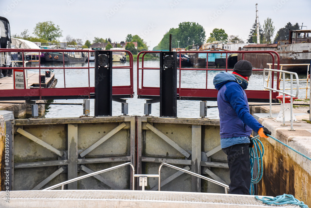 woman locking through a lock chamber on a canal in France