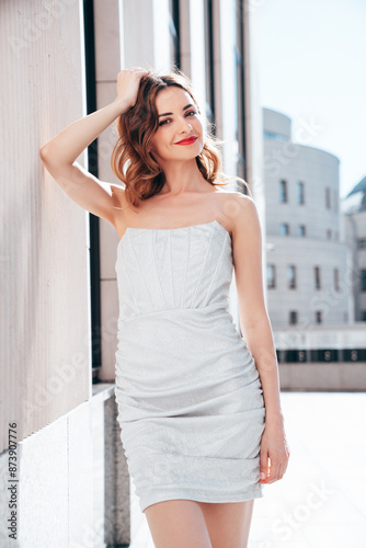 Young beautiful smiling brunette female in trendy evening silver dress. Sexy carefree woman posing in the street at sunny day. Fashionable model with evening bright makeup and red lips, outdoors Free Download Young beautiful smiling brunette female in trendy evening silver dress. Sexy carefree woman posing in the street at sunny day. Fashionable model with evening bright makeup and red lips, outdoors - GFXLoad