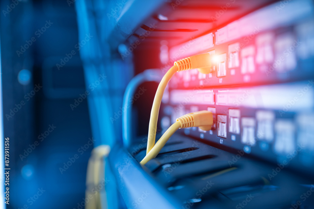 Fototapeta premium close up of network cables connected to server racks in data center room.