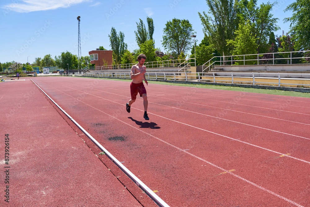 A man runs on a track with a red background A man runs on a track with a red background
