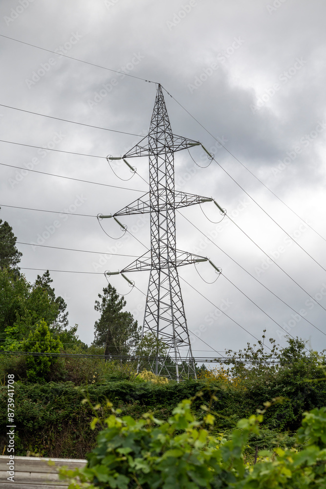 Foto de A tall metal transmission tower carries multiple high voltage ...