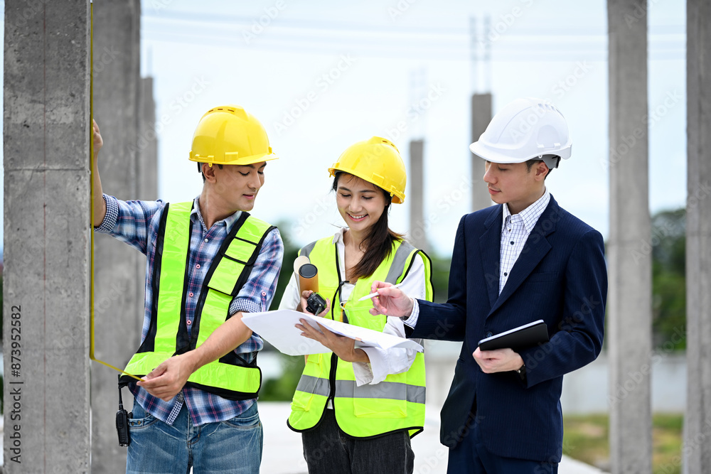Team of structural engineers and businessman planning development details about project at construction site Team of structural engineers and businessman planning development details about project at construction site