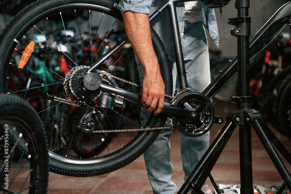 Obraz premium Close up view of man's hands that is repairing bicycle