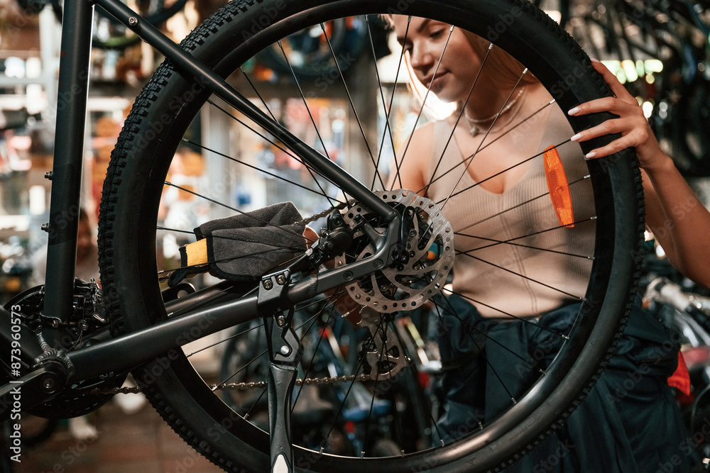 Making it clean. Repair woman in bicycle shop, working in store Making it clean. Repair woman in bicycle shop, working in store