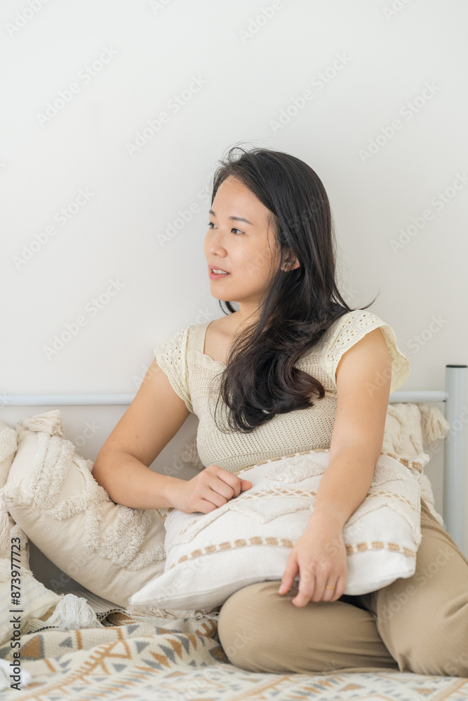 A Chinese Malaysian woman in her 20s wearing casual, warm-colored clothing, playing with a cat in her home in Malaysia A Chinese Malaysian woman in her 20s wearing casual, warm-colored clothing, playing with a cat in her home in Malaysia