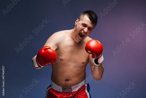 Boxer wearing red boxing gloves throwing a punch and yelling