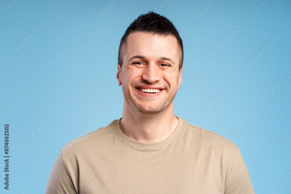 Portrait of smiling happy man, close-up, isolated on blue background, looking at camera Portrait of smiling happy man, close-up, isolated on blue background, looking at camera