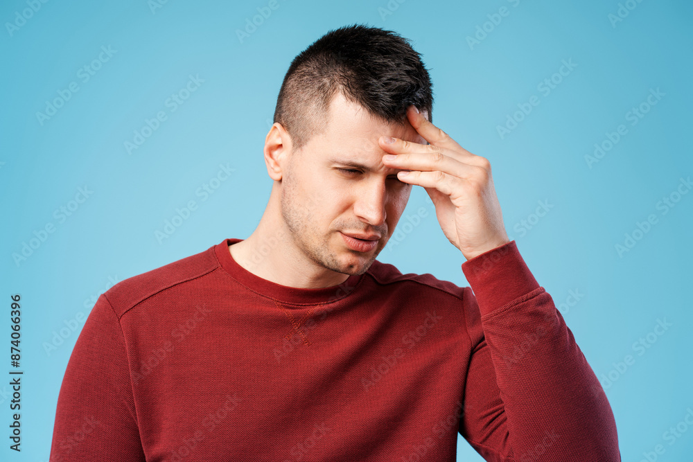 Middle worried man standing holding hand to forehead, worried by headache, migraine Middle worried man standing holding hand to forehead, worried by headache, migraine