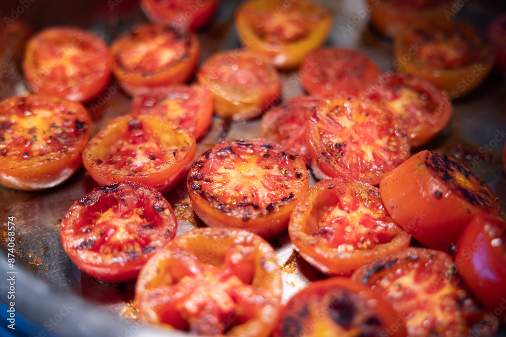A pan of grilled tomatoes with a lot of char marks A pan of grilled tomatoes with a lot of char marks