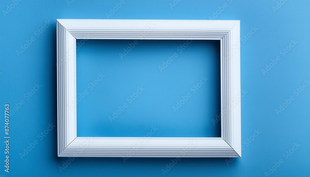 Modern white rectangular frame on blue background. Frame for photos, painting. Flat lay. Close-up Modern white rectangular frame on blue background. Frame for photos, painting. Flat lay. Close-up