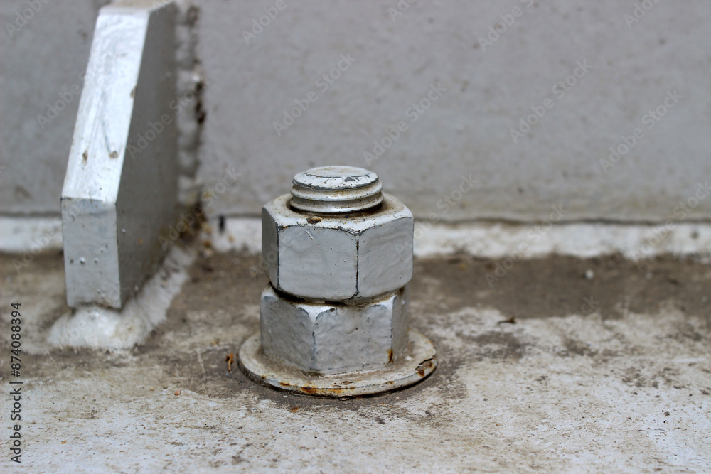 A large, old, rusted nut attached to the steel base structure. A large, old, rusted nut attached to the steel base structure.