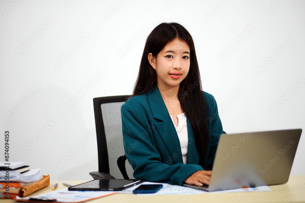 Beautiful Asian businesswoman work using a tablet and a laptop with documents placed at the office. Beautiful Asian businesswoman work using a tablet and a laptop with documents placed at the office.