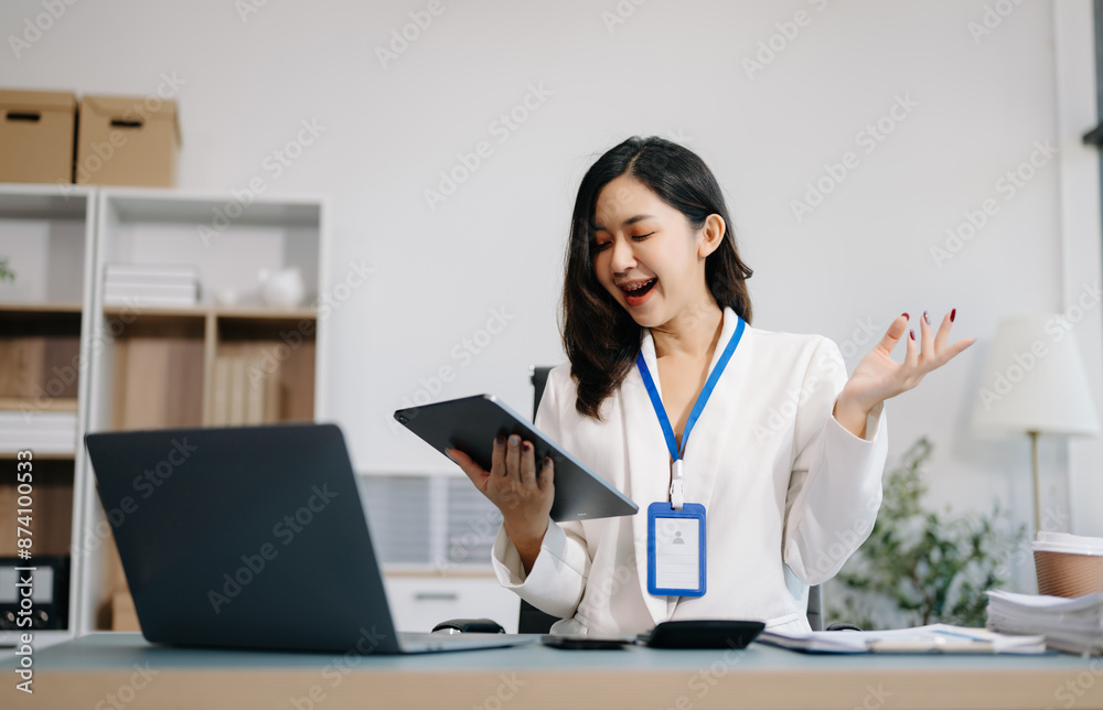 Asian Businesswoman Analyzing Finance on Tablet and Laptop at modern Office Desk Asian Businesswoman Analyzing Finance on Tablet and Laptop at modern Office Desk
