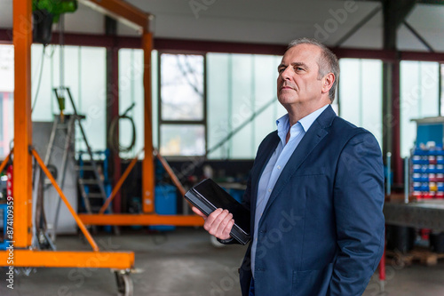Wallpaper Mural Thoughtful senior businessman holding diary at factory Torontodigital.ca