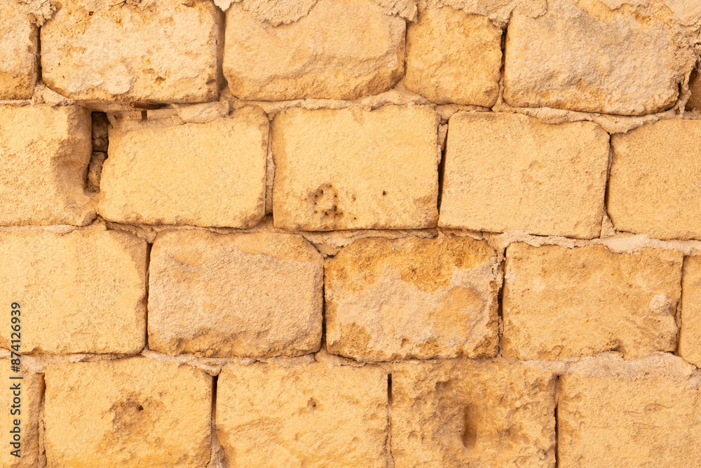 A wall of weathered yellow stones A wall of weathered yellow stones