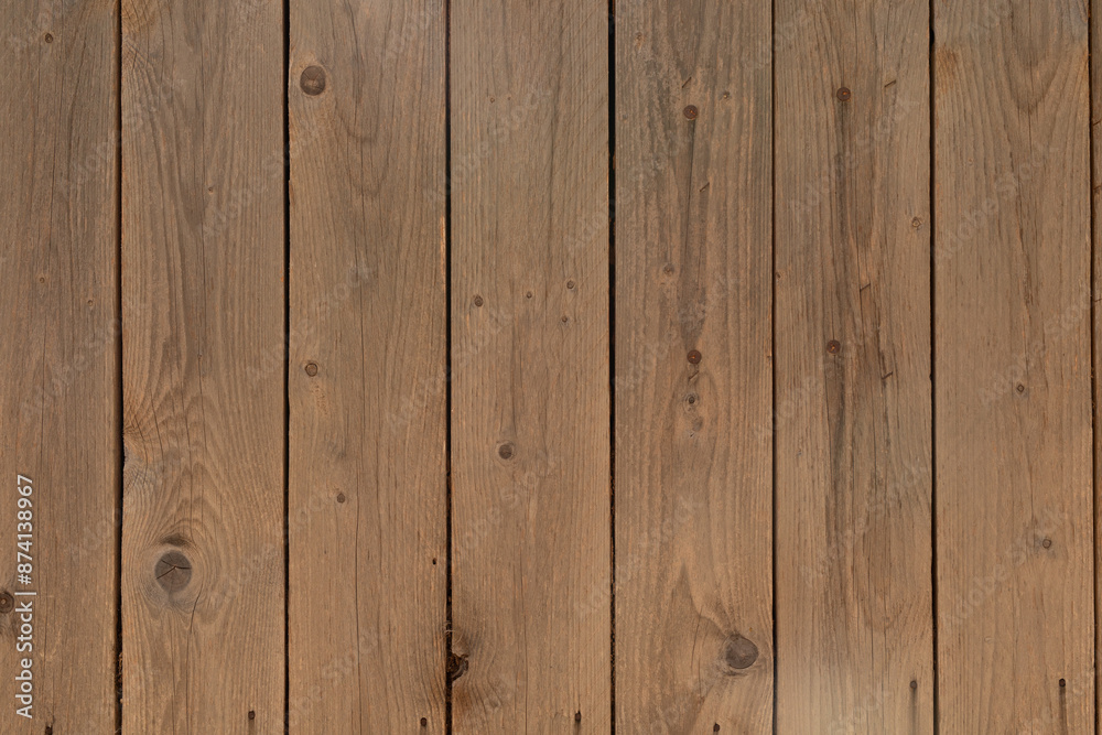 A weathered wooden fence with vertical planks A weathered wooden fence with vertical planks
