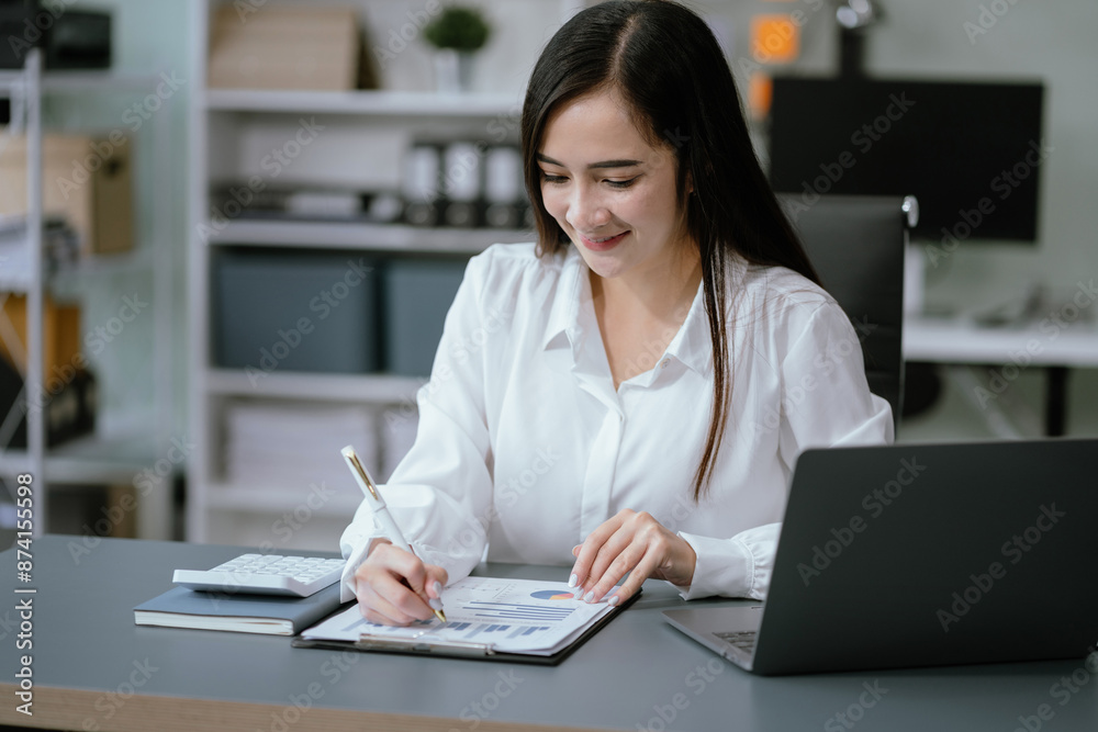Business documents on the desk with a laptop and a Tablet with graphs, business diagrams and women working in the office. Business documents on the desk with a laptop and a Tablet with graphs, business diagrams and women working in the office.