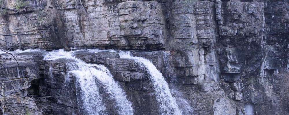 Fototapeta premium Waterfall running into river in the Rocky mountains